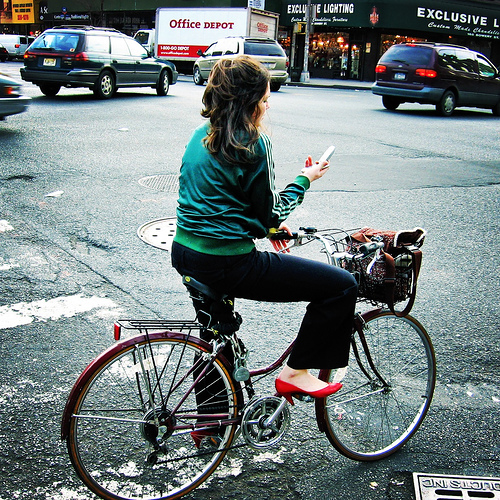 woman bicycle red shoes and cell phone