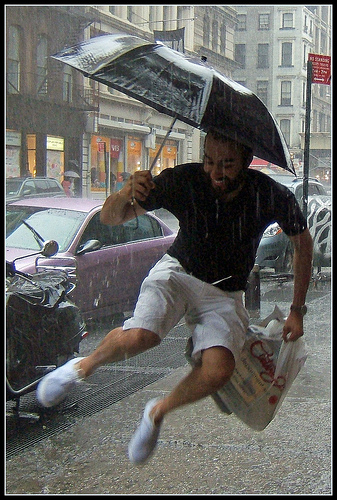 man jumping with umbrella in the rain New York